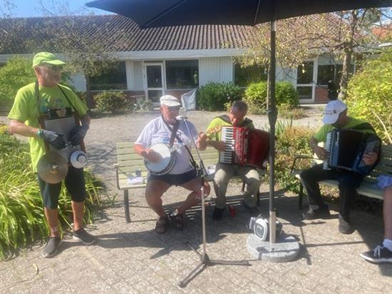 jazzmusikere på vaskebræt, banjo og harmonikaer underholder i gårdhaven på Solgården
