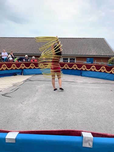 Cirkusprinsessen jonglerer med mange guld-hulahopringe