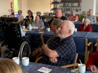 Beboere og pårørende sidder ved borde og drikker Irish coffee i cafeen på Solgården Beboere og pårørende sidder ved borde og drikker Irish coffee i cafeen på Solgården