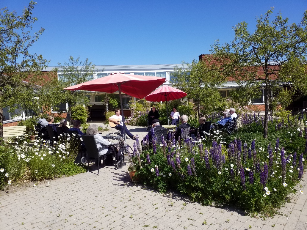 Personale underholder med musik og sang i atriumgården i coronatiden Personale underholder med musik og sang i atriumgården i coronatiden